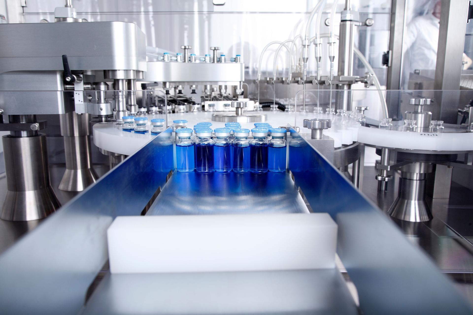 Glass bottles in production in the tray of an automatic liquid dispenser, a line for filling medicines against bacteria and viruses, antibiotics and vaccines